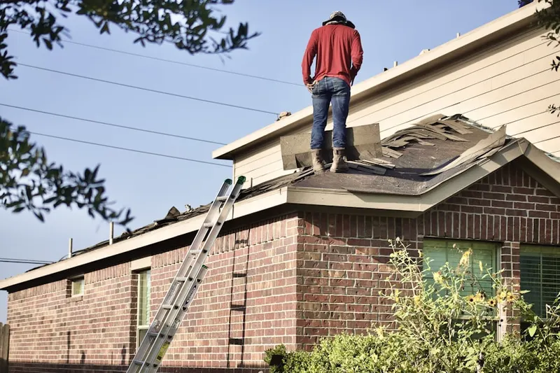Professional roofer working on a residential roof in Omak